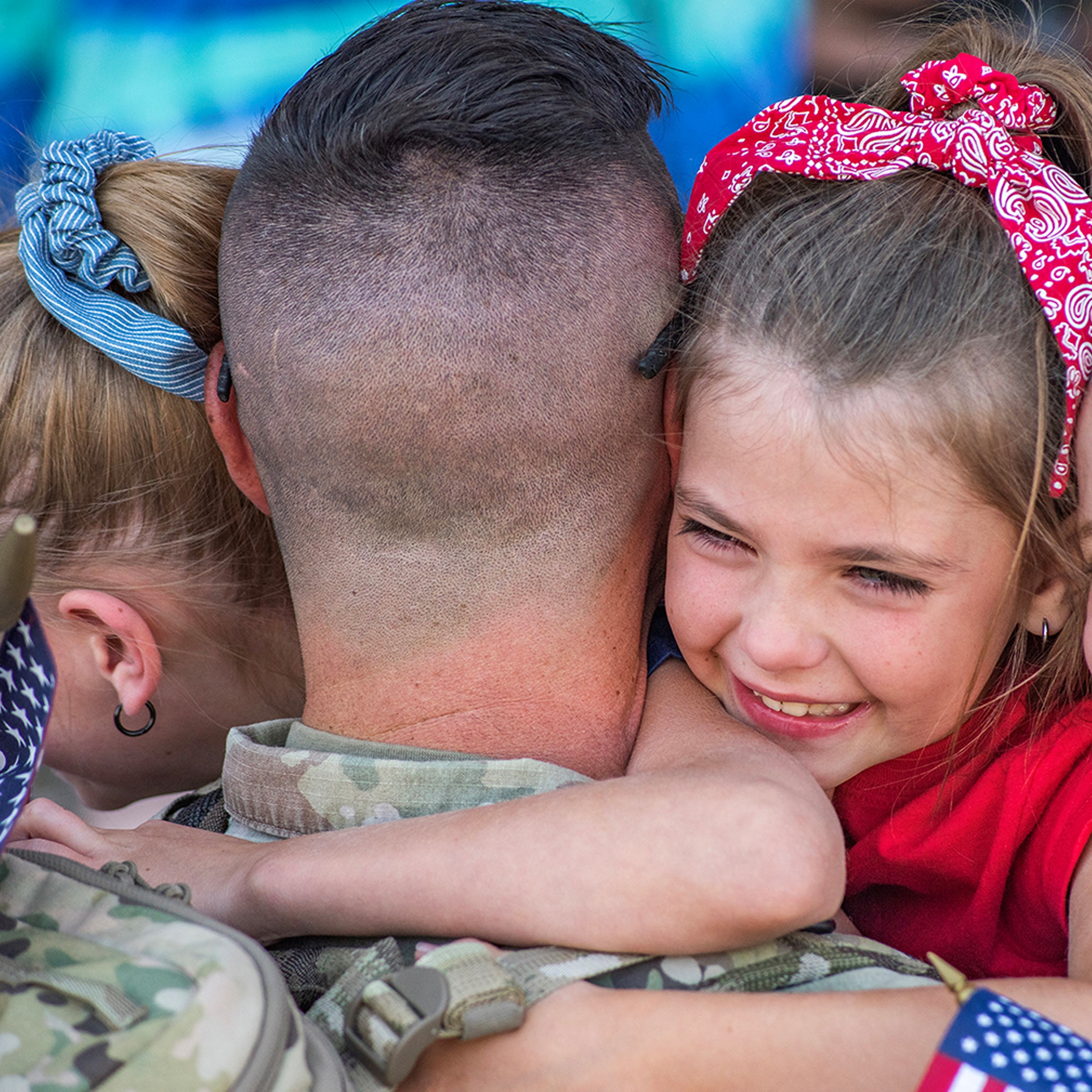 A military member hugs his children